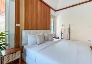 a white bed in a room with a large window at 提供免费汽车使用的含泳池被墅房间 in Chiang Mai