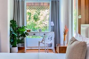 a bedroom with a desk and a chair in front of a window at 提供免费汽车使用的含泳池被墅房间 in Chiang Mai