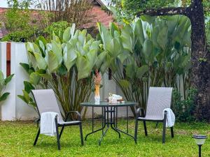 two chairs and a table with a vase on it at 提供免费汽车使用的含泳池被墅房间 in Chiang Mai