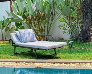 a chaise lounge sitting next to a swimming pool at 提供免费汽车使用的含泳池被墅房间 in Chiang Mai