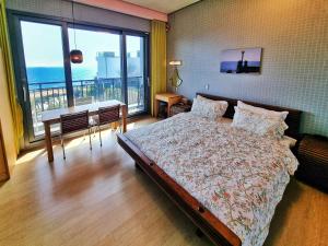 a bedroom with a bed and a view of the ocean at OROJEJU in Seogwipo