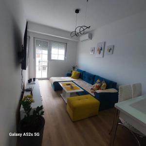 a living room with a blue couch and a yellow chair at Apartment Antonia - Gevgelija in Gevgelija