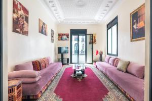 丹吉尔Hotel Mauritania的客厅配有紫色沙发和地毯。