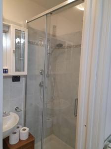 een badkamer met een glazen douche met wastafel bij La Casa di Franci in Levanto +15 foto's