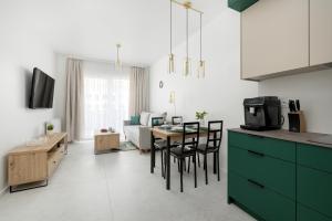 a kitchen and living room with a table and chairs at Lets Sea Baltic Park by Solarento in Gąski