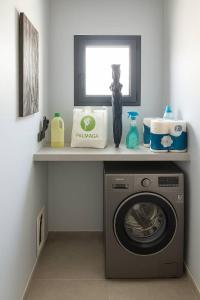 a laundry room with a washing machine on a shelf at Villa Mona in Somone