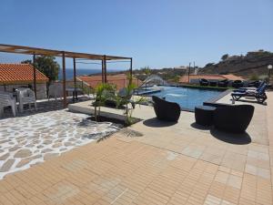 a patio with a swimming pool with chairs at Encosta Azul in Cidade Velha +38 photos