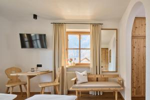 a room with a chair and a table and a window at Haus Tirol in Molini di Tures