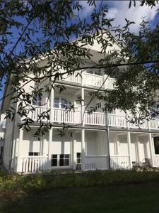 a large white building with a balcony on it at Große Freiheit in Ostseebad Nienhagen