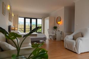 a living room with a bed and a table and chairs at Fabulous 5 BR hidden gem Serra da Estrela in Vinhó