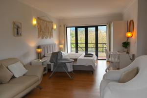 a bedroom with a bed and a living room at Fabulous 5 BR hidden gem Serra da Estrela in Vinhó