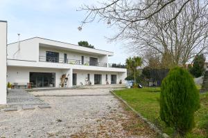a white house with a gravel driveway at Fabulous 5 BR hidden gem Serra da Estrela in Vinhó