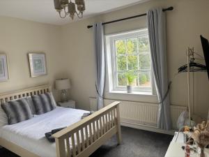 a bedroom with a bed and a window at Three Tuns Ashwell in Ashwell