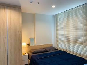 a bedroom with a bed and a window with blinds at 라싼콘도 in Bangna +7 photos