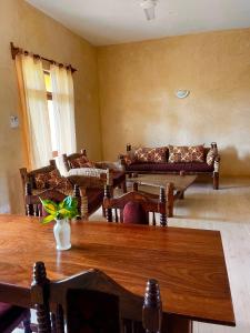 un salon avec des canapés et une table dans l'établissement Flametree Beach Homes, à Diani Beach