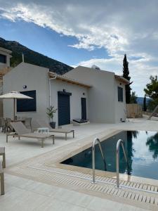 a villa with a swimming pool in front of a house at Stone Crafted Luxury Villas in Nikiana