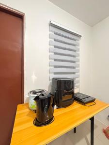 a coffee maker and a toaster on a wooden table at Zebs cozy cove in Cebu City