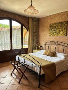 a bedroom with a large bed and a chair at Agriturismo Tenuta San Giuseppe in Cossano Belbo