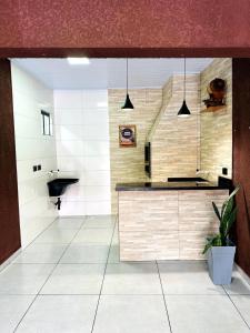 uma grande cozinha com um balcão e um lavatório em Cantinho Aconchegante in Foz em Foz do Iguaçu