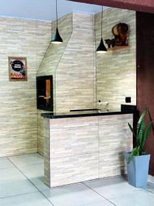 uma casa de banho com uma parede de pedra e uma lareira em Cantinho Aconchegante in Foz em Foz do Iguaçu