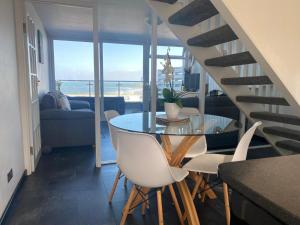 a dining room with a table and chairs with a view of the ocean at Stunning Sea View Apartment in Newquay with a Pool in Crantock