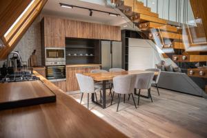 eine Küche mit einem Holztisch und Stühlen in der Unterkunft AVA Chalet in Comarnic