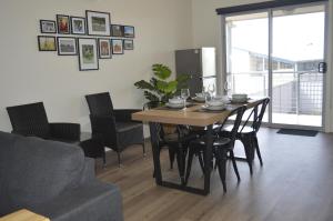 ein Wohnzimmer mit einem Tisch mit Stühlen und einer Couch in der Unterkunft Copper Retreat Millennium Apartment in Roxby Downs