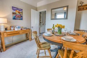 a dining room with a wooden table and chairs at Strand Cottage - Sheringham - Crabpot Cottages Sheringham in Sheringham +14 photos