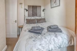 a bedroom with a bed with two pillows on it at Strand Cottage - Sheringham - Crabpot Cottages Sheringham in Sheringham