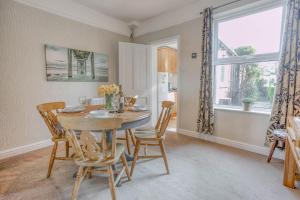 a dining room with a table and chairs and a window at Strand Cottage - Sheringham - Crabpot Cottages Sheringham in Sheringham
