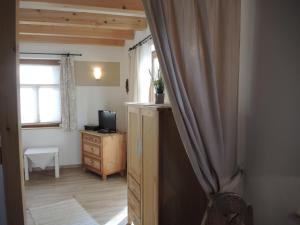 a room with a television and a dresser and a window at Landgut Seebühne Steigerwald - Guesthouse in Vestenbergsgreuth
