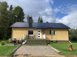 a small yellow house with a porch and stairs at Fjällnära Villa i Vidsel in Vidsel