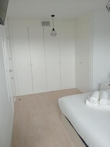 ein weißes Zimmer mit weißen Schränken und einem Bett in der Unterkunft KOTA Zero Rivas Center 500 in Rivas-Vaciamadrid + 18 Fotos
