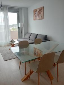 ein Wohnzimmer mit einem Glastisch und Stühlen in der Unterkunft KOTA Zero Rivas Center 500 in Rivas-Vaciamadrid