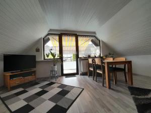 a living room with a tv and a table with chairs at FeWo Karola in Ellenz-Poltersdorf