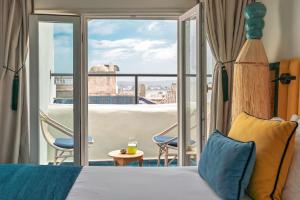 a hotel room with a bed and a balcony at Le Palazzo in Essaouira