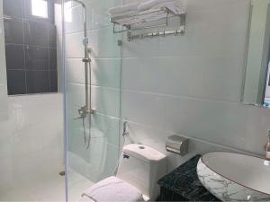 ダラットにあるKhách Sạn Đà Lạt DP Gần Chợ Đêm 2 phútのトイレと洗面台を備えた白いバスルーム +22枚の写真