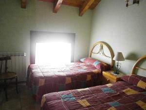 1 dormitorio con 2 camas y ventana en Casa Miguel Périz, en Sorripas