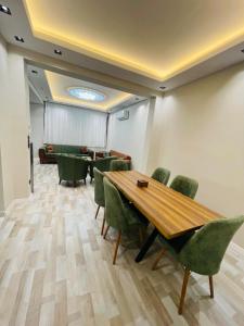 una sala de conferencias con mesa de madera y sillas verdes en Amora Suites, en Estambul