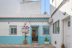 a blue and white house with a potted plant at Casa Buganvilla in Barbate