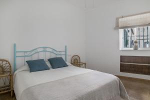 a bedroom with a large bed with two blue pillows at Casa Buganvilla in Barbate