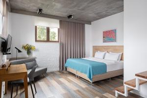 a bedroom with a bed and a desk and a couch at Mariinsky Boutique Hotel in Batumi