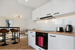 a kitchen with white cabinets and a stove top oven at Top Loft mit Gartenterrasse in Greifswald