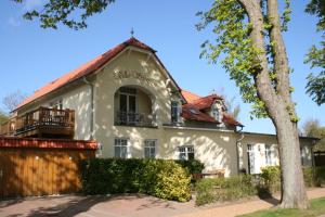 a white house with a red roof at Ferienwohnung in der Villa Seestern in Nienhagen