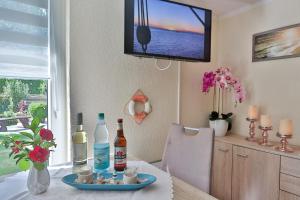 a dining room with a table with bottles and a television at Bungalow Konrad in Kühlungsborn +11 photos