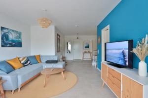 a living room with a couch and a flat screen tv at Flunder in Börgerende-Rethwisch +11 photos