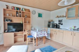 a kitchen with a table and a tv in a room at FeWo Lavendel in Kröpelin