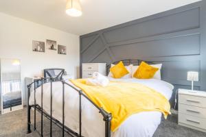 a bedroom with a large bed with yellow pillows at Newly Refurbed, Driveway, 4-BR House, Ensuite in Northampton