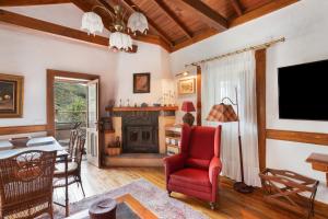a living room with a red chair and a fireplace at El Estanco 14 in Vega de San Mateo