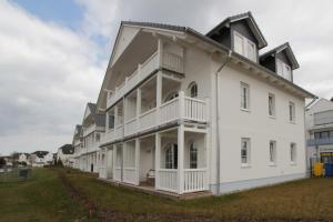 Un gran edificio blanco con un gran patio. en Strandlust, en Ostseebad Nienhagen